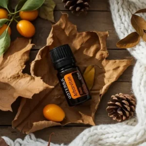 Żywotnik doTERRA na jesiennej dekoracji z liśćmi i szyszkami